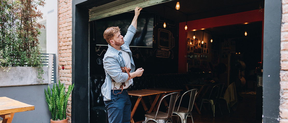 A man opening a door to a business